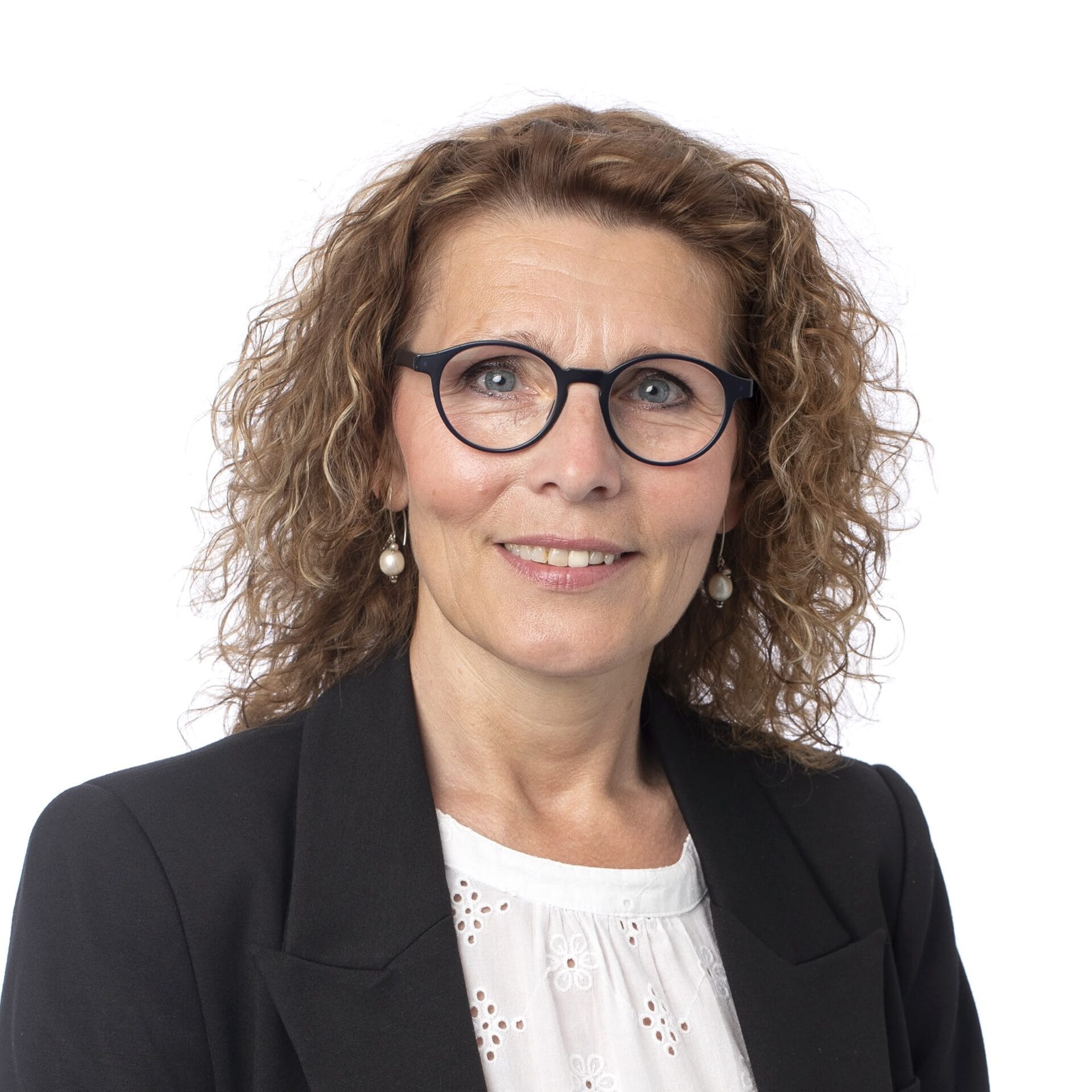 Kvinde med krøllet hår og briller smiler professionelt